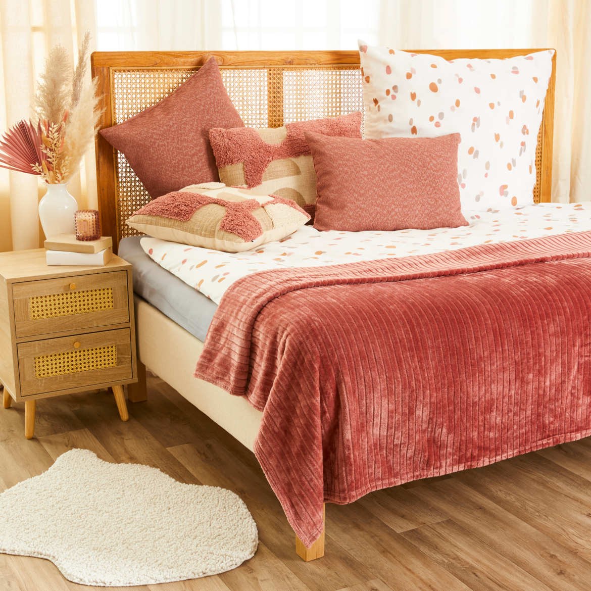 Bett mit roter Decke und weißen und roten Kissen